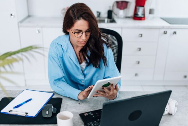 Mujer trabajando en un escritorio con una computadora y una tableta