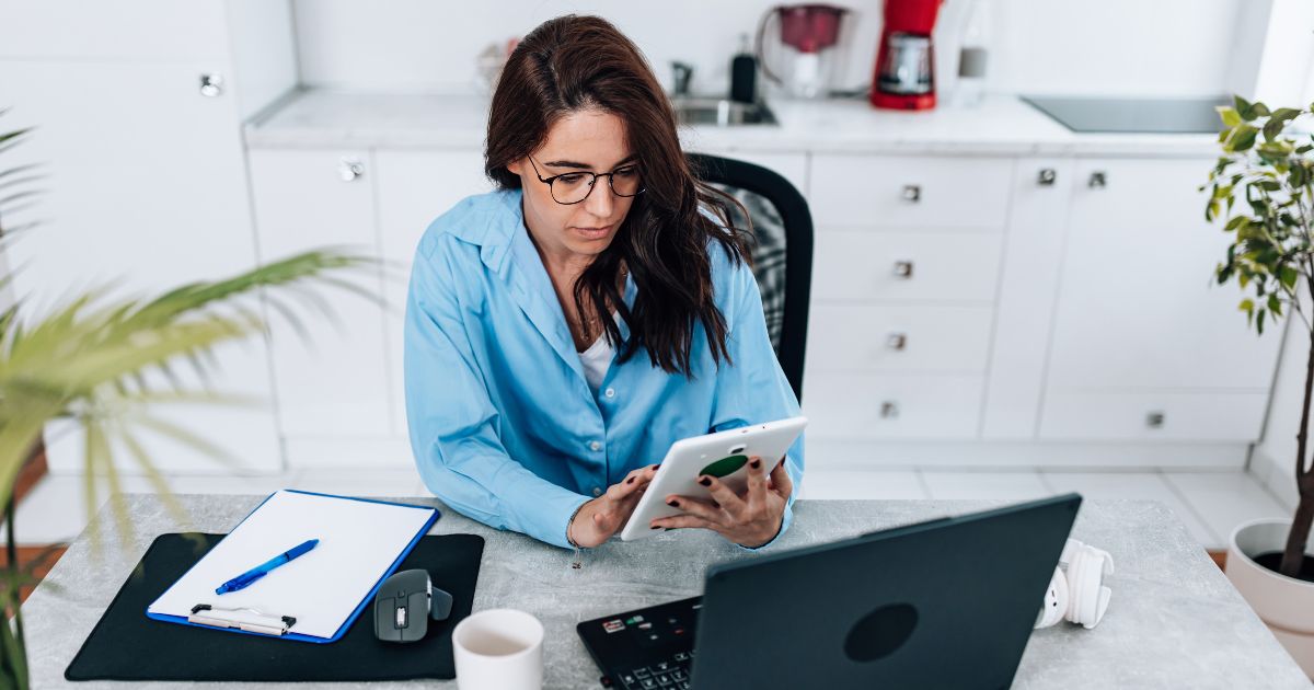 Mujer trabajando en un escritorio con una computadora y una tableta